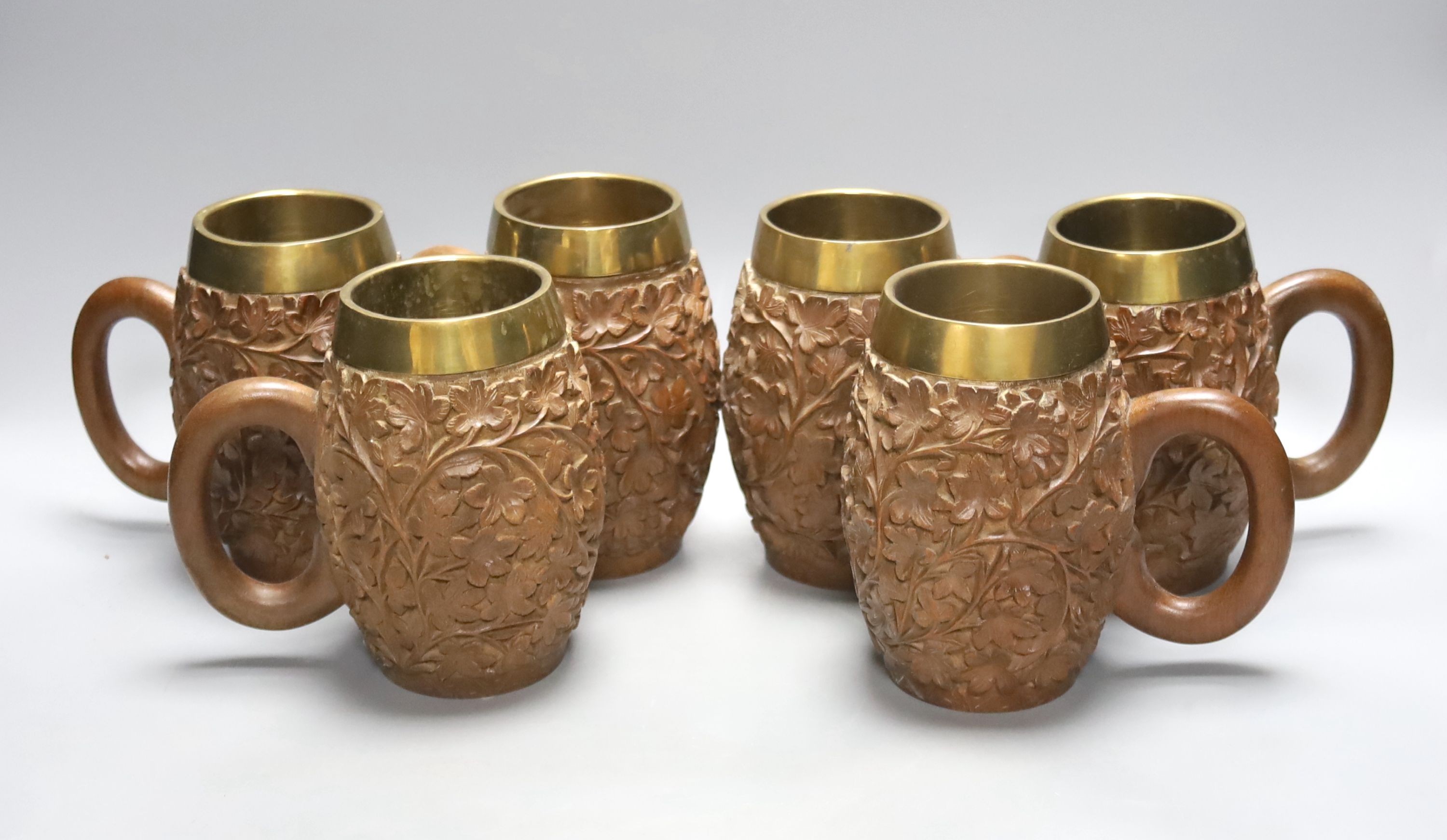 A set of six South Asian carved teak mugs 15.5cm